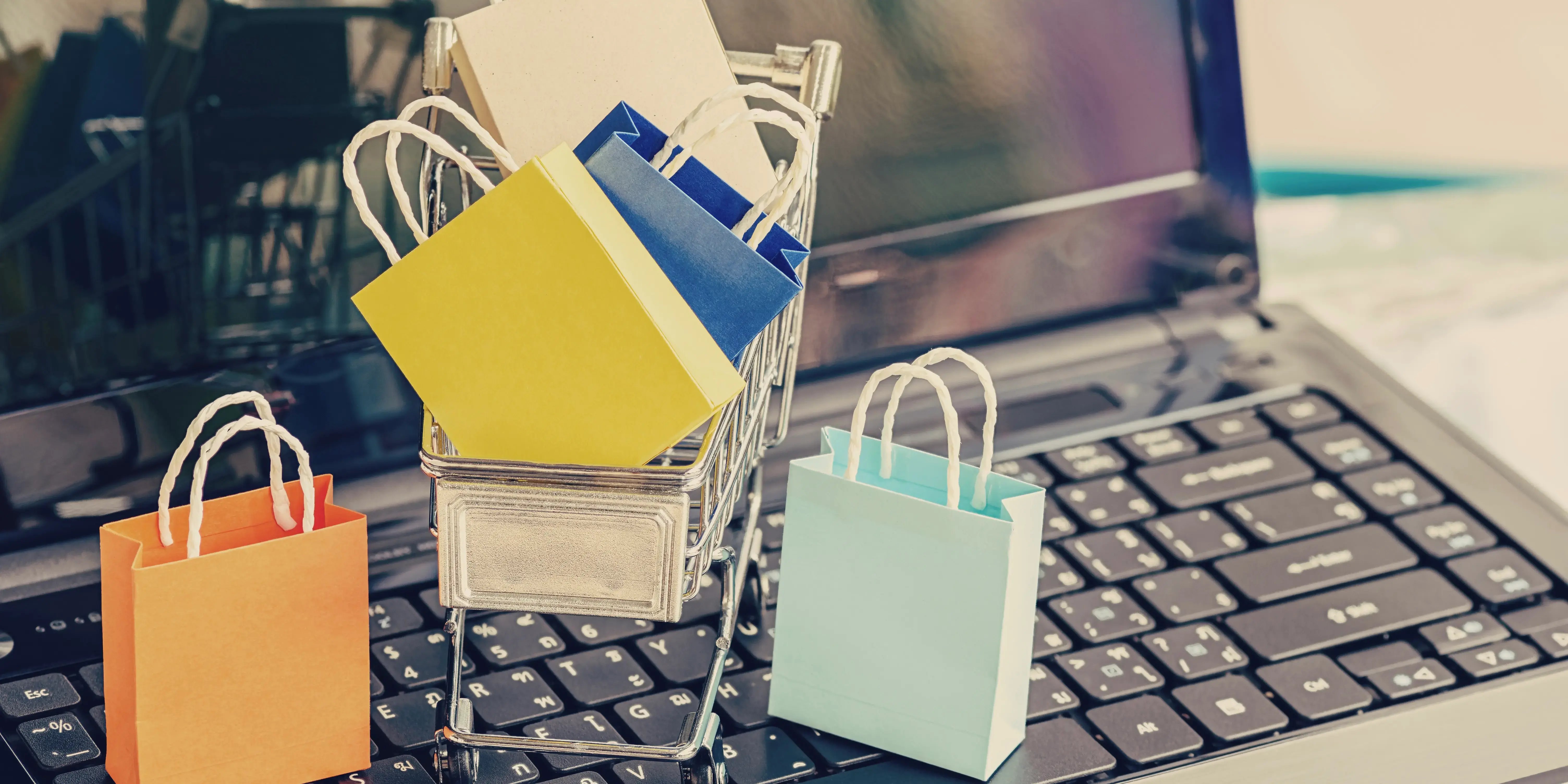 Computadora con carrito de compras encima para evitar gastos inecesarios y crear un presupuesto para comprar casa