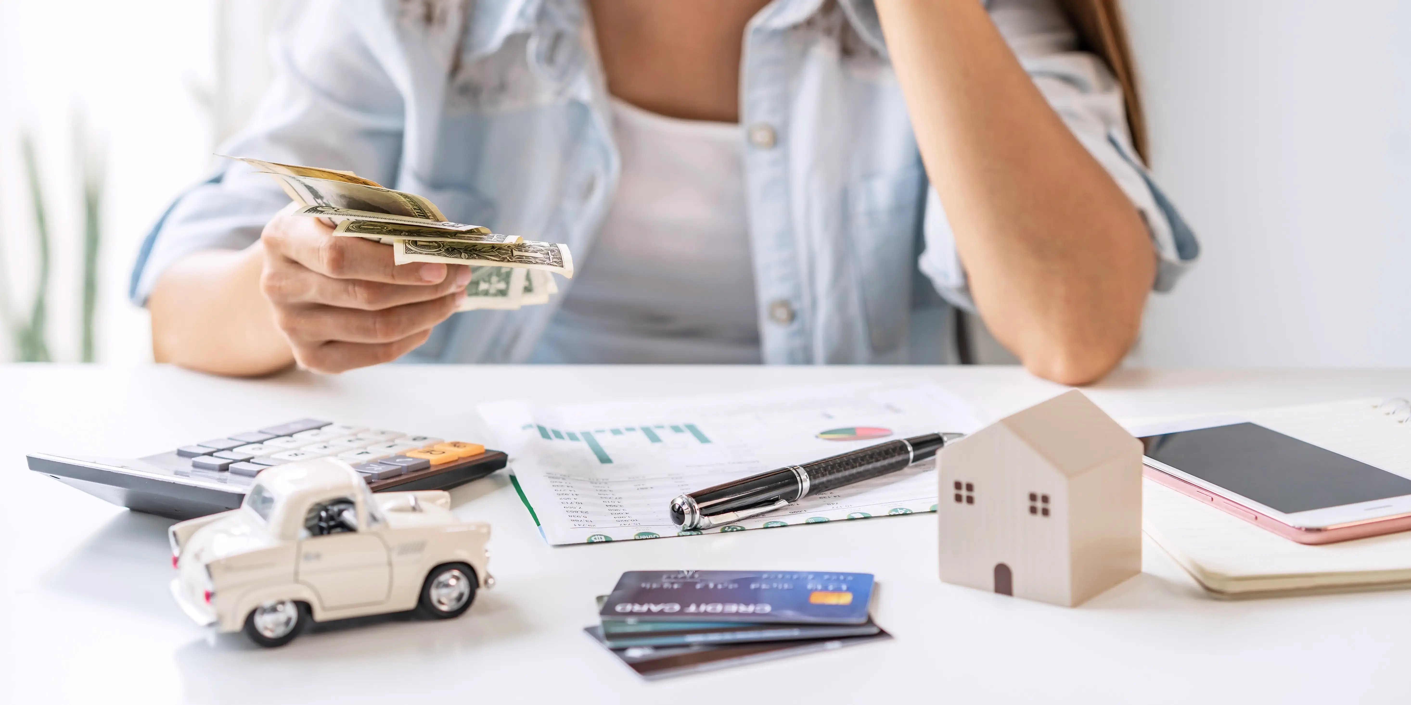Mujer calculando los gastos mensuales del hogar para empezar a ahorrar y comprar casa propia