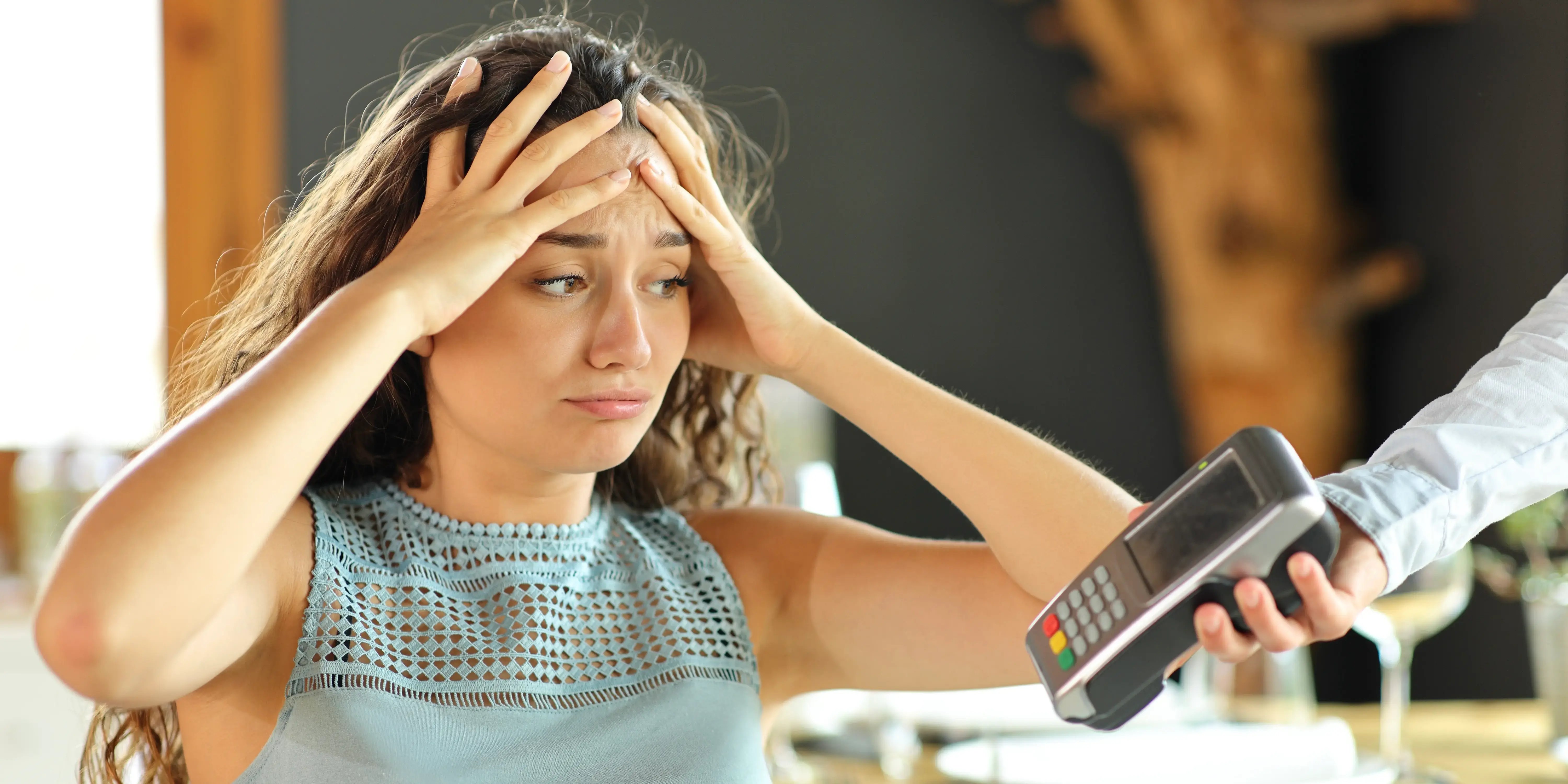 Mujer preocupada de las finanzas y quejándose de la costosa cuenta del restaurante y gastos hormiga