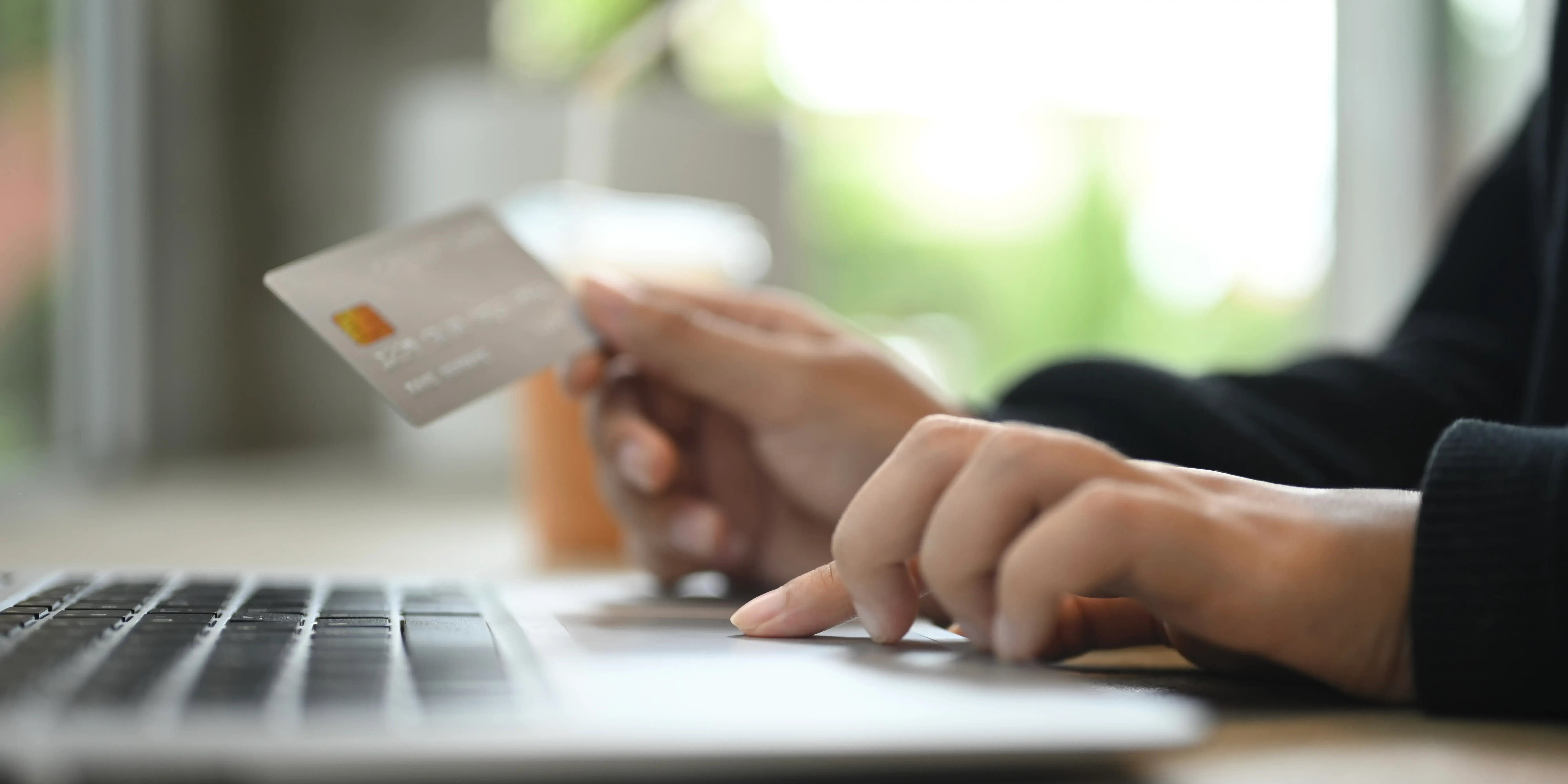 Persona en la computadora pagando a tiempo su tarjeta para tener un buen historial crediticio